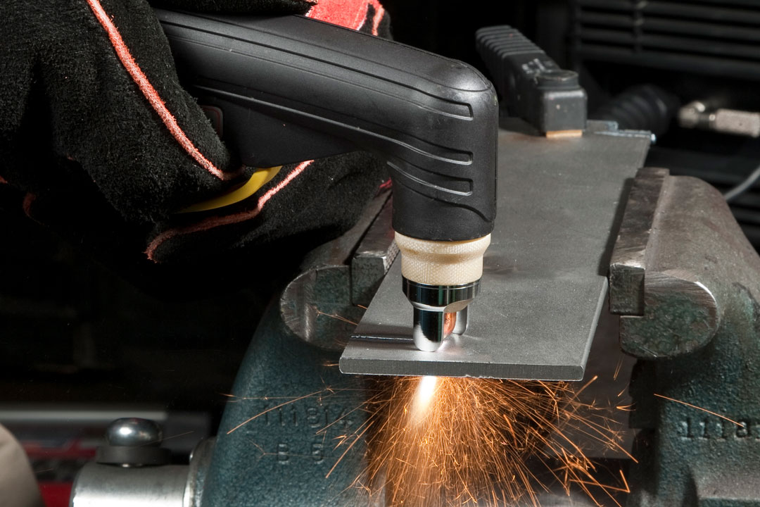 A manual plasma cutter cutting a component for large tooling or flight hardware for the aerospace, defense, and space industry