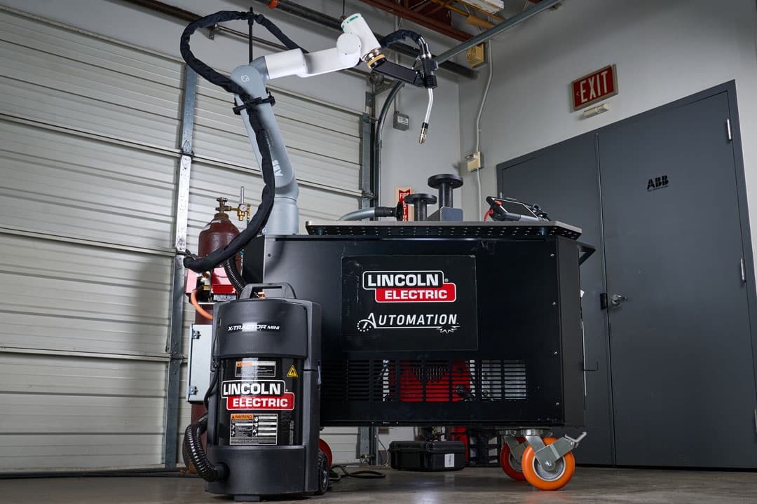 An image of Lincoln Electric's collaborative welding robot cart and X-Tractor Mini welding fume extractor inside a warehouse