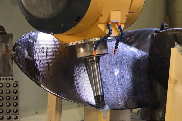 A large 5-axis CNC machine machining a propeller for the shipbuilding industry