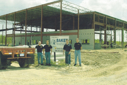 Kevin Baker, Scott Baker, Bill Ednie, and one other employee standing in front of the construction site for Baker Industries Plant 1 in Macomb, Michigan
